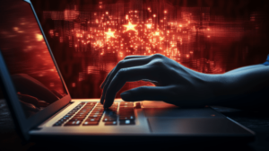 A hand in dimly lit room types on a laptop in front of a glowing red digital Chinese flag with gold stars